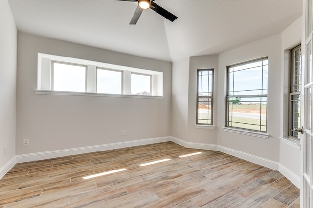 spare room with lofted ceiling, light wood-type flooring, and ceiling fan