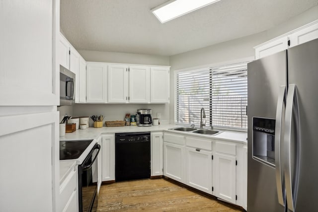 kitchen featuring white cabinetry, a textured ceiling, light hardwood / wood-style flooring, black appliances, and sink