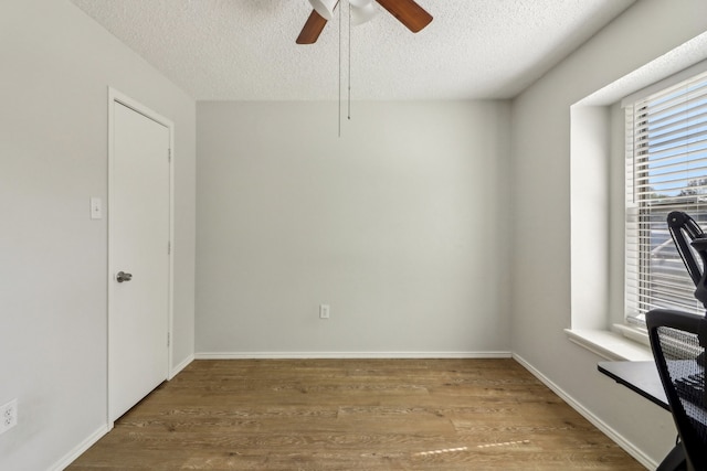 spare room featuring ceiling fan, hardwood / wood-style flooring, and a textured ceiling