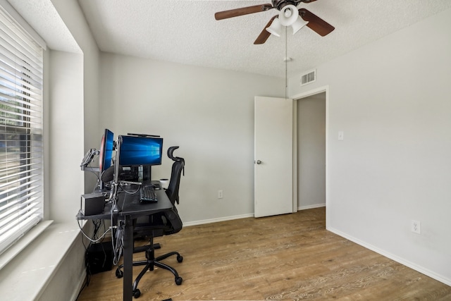 home office featuring light hardwood / wood-style flooring, a textured ceiling, and ceiling fan