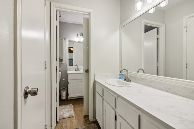 bathroom featuring vanity, hardwood / wood-style floors, and a textured ceiling