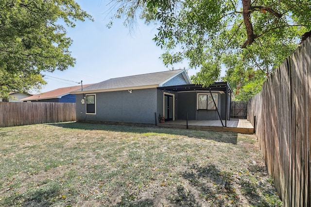 rear view of property featuring a yard and a wooden deck