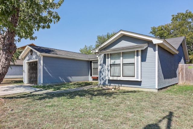 view of front of home featuring an outdoor structure, a garage, and a front lawn