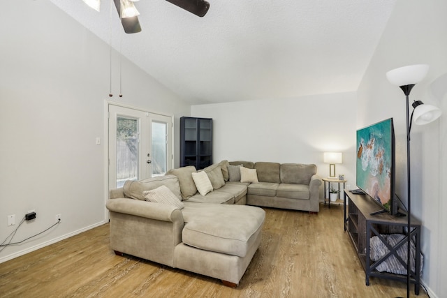 living room with ceiling fan, a textured ceiling, high vaulted ceiling, wood-type flooring, and french doors