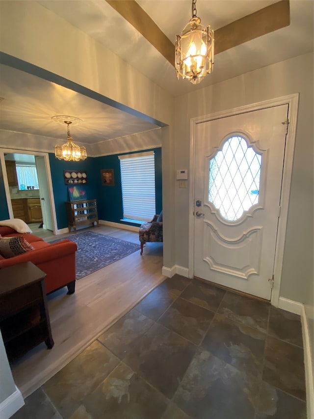 foyer featuring a healthy amount of sunlight, a raised ceiling, and a chandelier