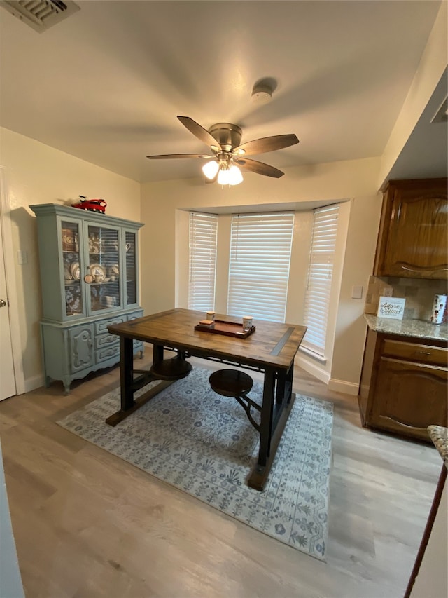 dining room with light hardwood / wood-style flooring and ceiling fan