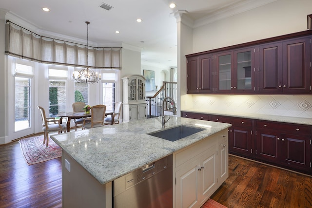 kitchen featuring a kitchen island with sink, ornamental molding, dishwasher, dark hardwood / wood-style floors, and sink