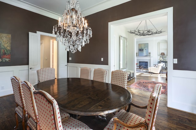 dining space with crown molding, dark hardwood / wood-style floors, and a chandelier