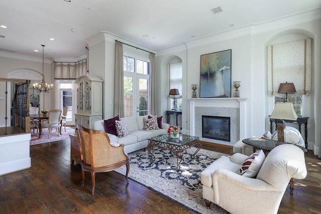 living room featuring an inviting chandelier, ornamental molding, and dark hardwood / wood-style flooring