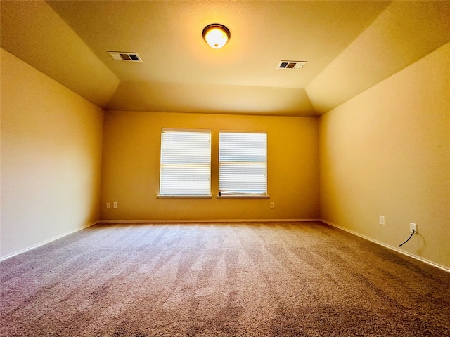 unfurnished room featuring carpet floors and vaulted ceiling