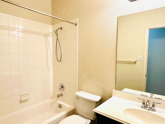 full bathroom with vanity, tiled shower / bath combo, and toilet