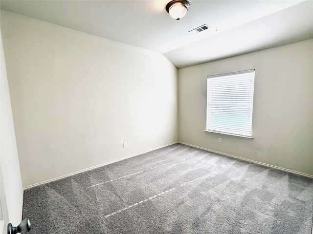 unfurnished room featuring lofted ceiling and carpet