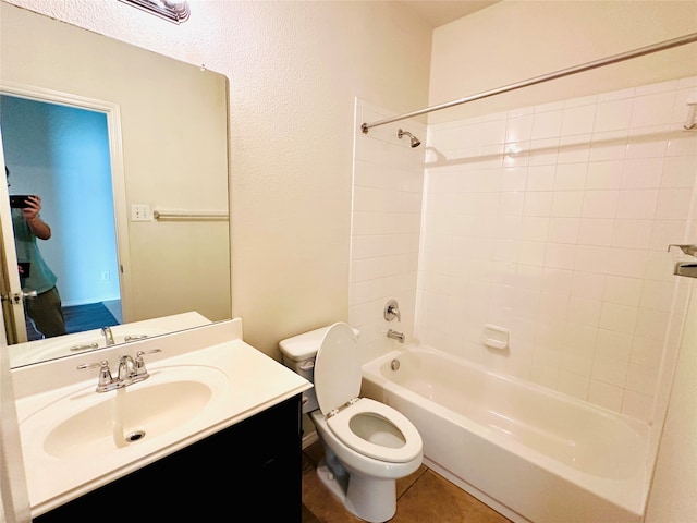 full bathroom with toilet, tiled shower / bath combo, vanity, and tile patterned flooring