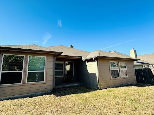 rear view of house featuring a lawn