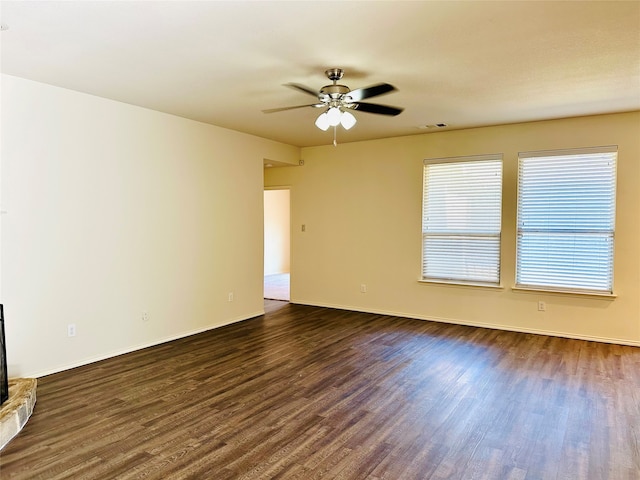 interior space with dark wood-type flooring, ceiling fan, and a fireplace