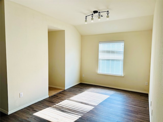 unfurnished room featuring vaulted ceiling and dark hardwood / wood-style flooring