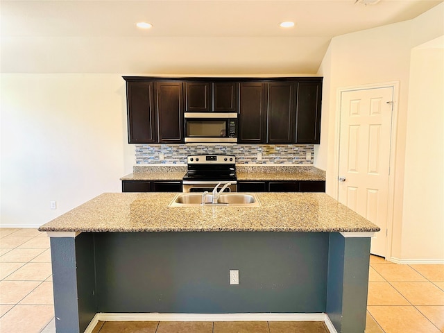 kitchen featuring appliances with stainless steel finishes, sink, an island with sink, and decorative backsplash