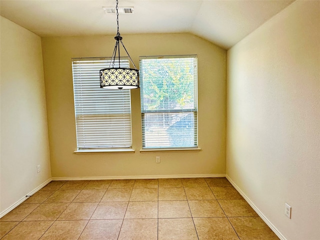 tiled spare room with vaulted ceiling