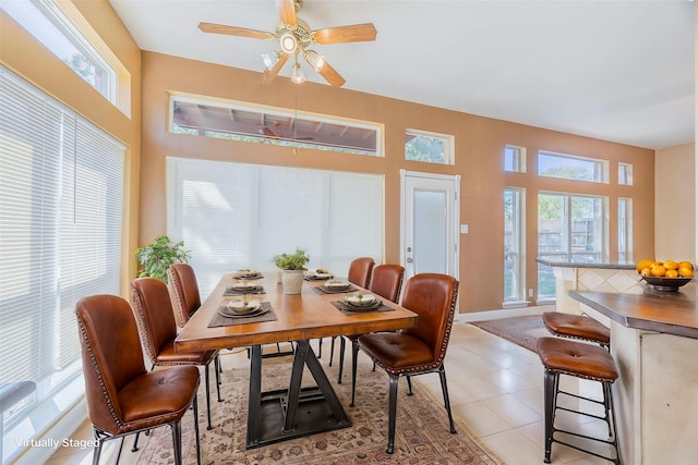 dining area with a ceiling fan, baseboards, and light tile patterned floors