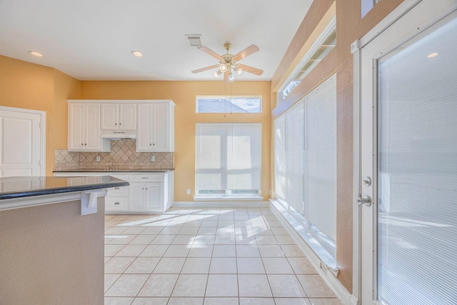 kitchen featuring white cabinetry, ceiling fan, tasteful backsplash, and light tile patterned floors