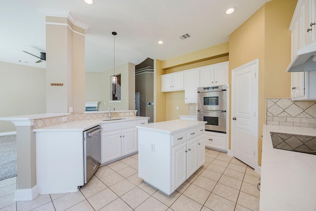 kitchen featuring tasteful backsplash, a sink, stainless steel appliances, visible vents, and a kitchen island