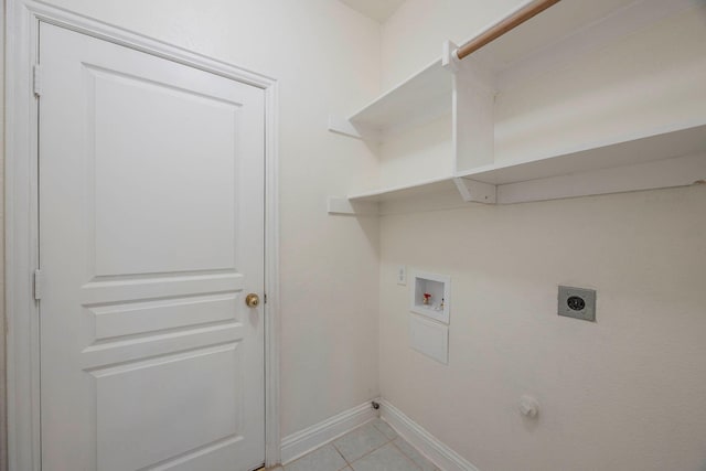 washroom with electric dryer hookup, washer hookup, and light tile patterned floors