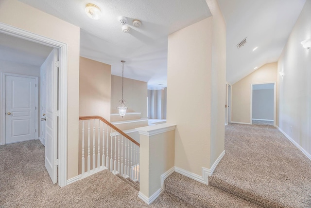 hall with vaulted ceiling and carpet