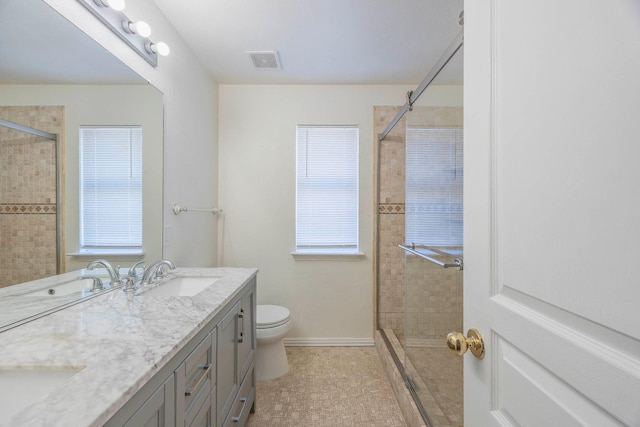 bathroom featuring vanity, toilet, and tiled shower