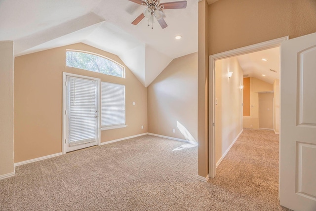 interior space with vaulted ceiling, light colored carpet, and ceiling fan