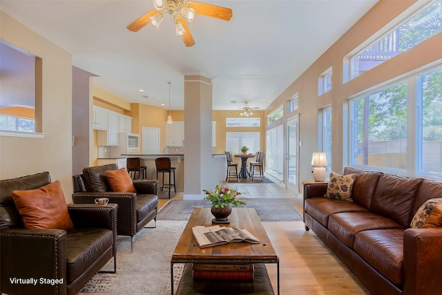 living room featuring decorative columns and ceiling fan