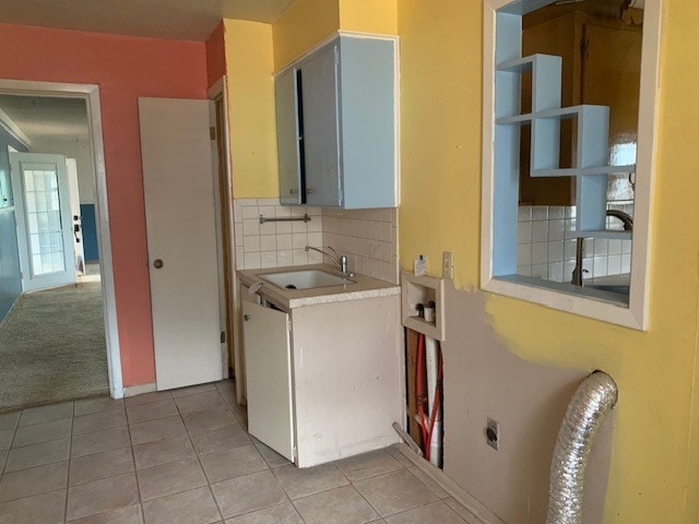 laundry area with cabinets, hookup for an electric dryer, sink, and light tile patterned floors