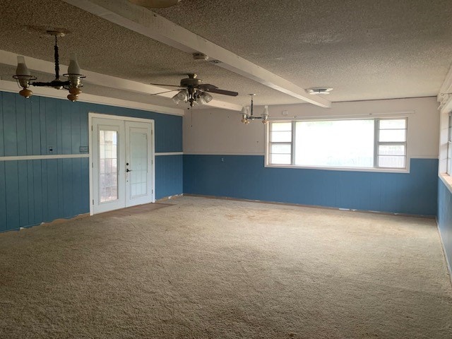 carpeted empty room with a textured ceiling, beam ceiling, and ceiling fan