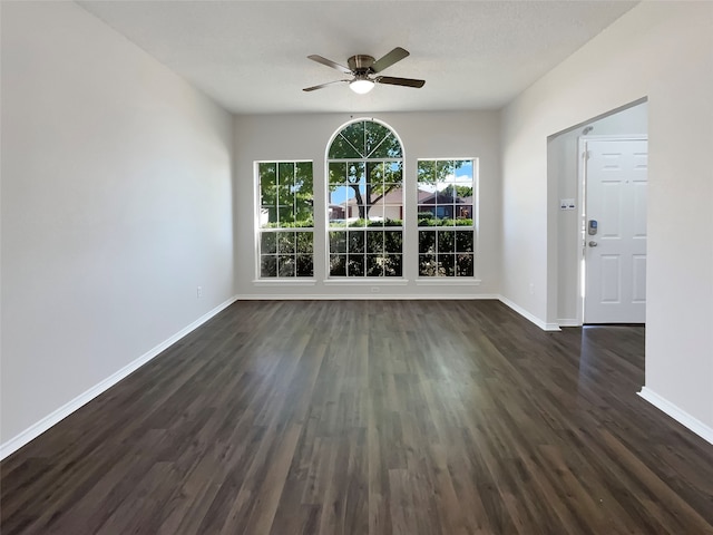 unfurnished room with ceiling fan, a textured ceiling, and dark hardwood / wood-style flooring