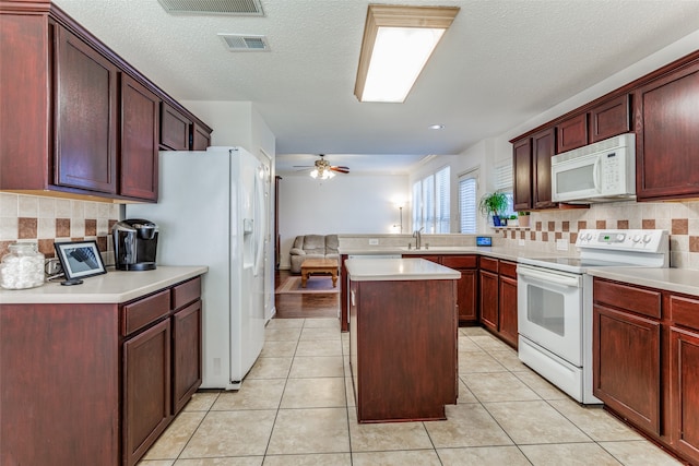 kitchen featuring a center island, ceiling fan, white appliances, and light tile patterned flooring