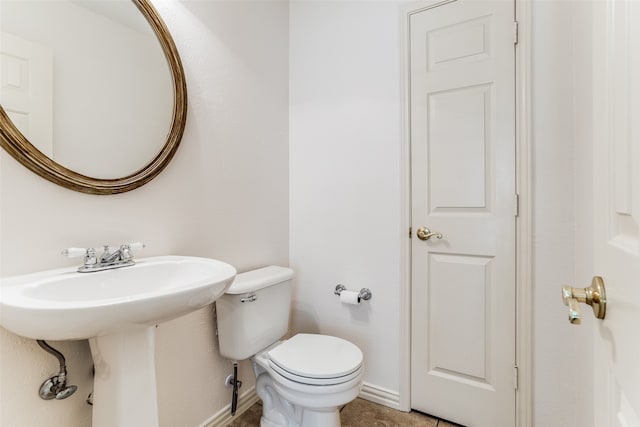 bathroom featuring toilet, tile patterned floors, and sink