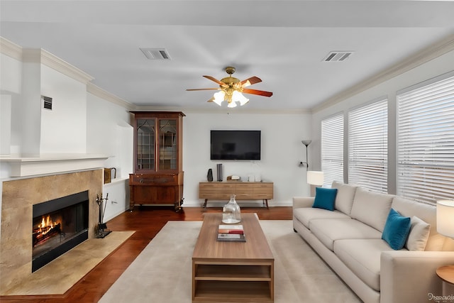 living room with crown molding, dark wood-type flooring, and ceiling fan