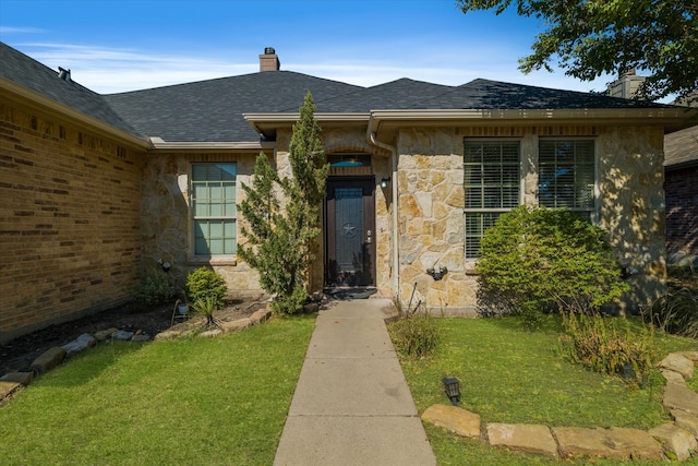 entrance to property with a lawn