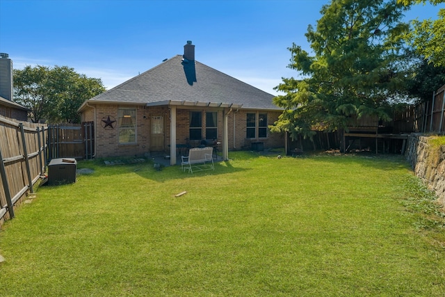 rear view of property featuring a lawn