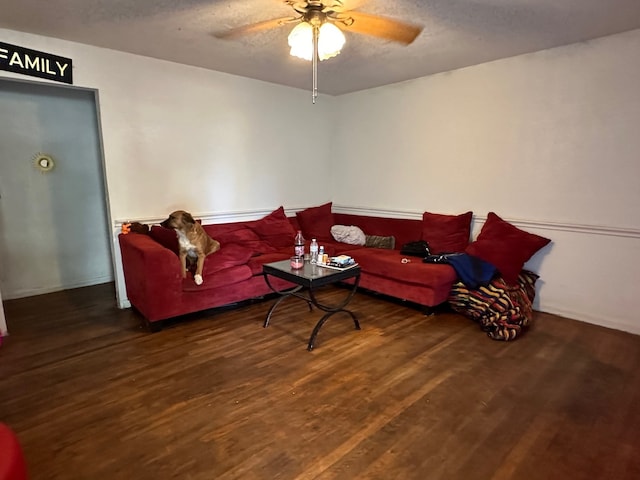 living room with dark hardwood / wood-style floors, a textured ceiling, and ceiling fan