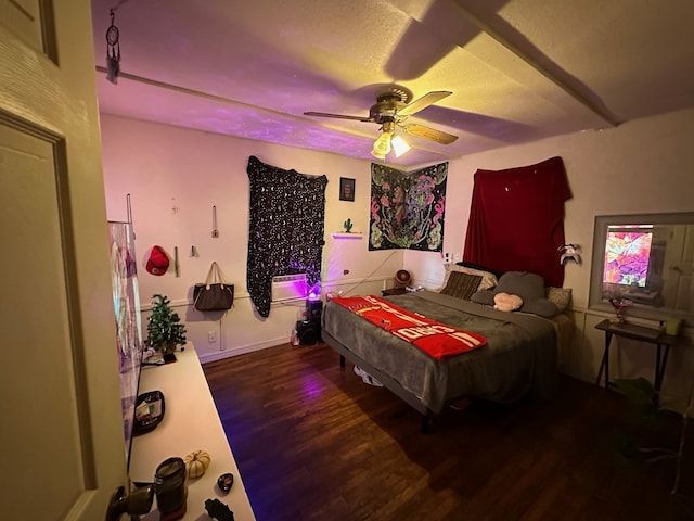 bedroom with dark wood-type flooring, a textured ceiling, and ceiling fan