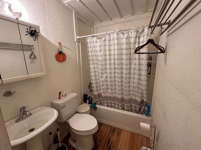 full bathroom featuring sink, shower / tub combo, hardwood / wood-style flooring, and toilet