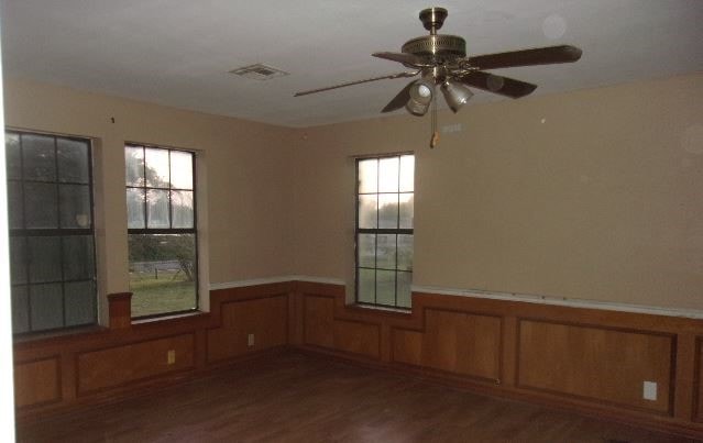 unfurnished room featuring dark wood-type flooring and ceiling fan