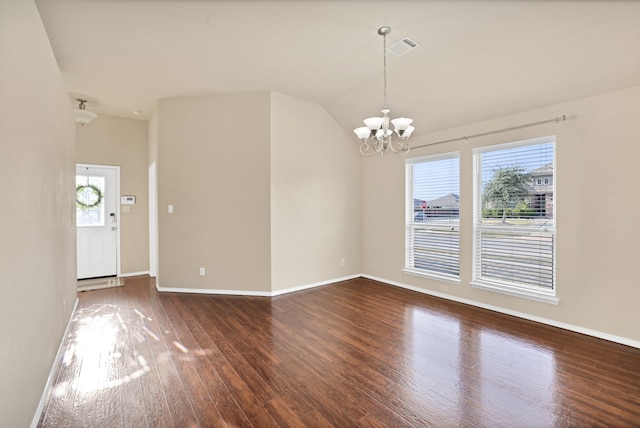 spare room with vaulted ceiling, a notable chandelier, and dark hardwood / wood-style floors