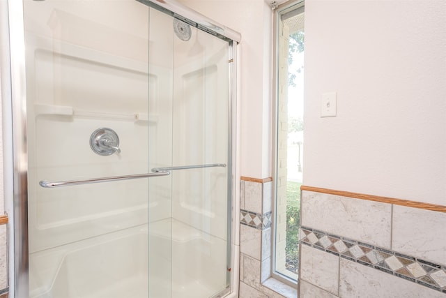 bathroom featuring a shower with door