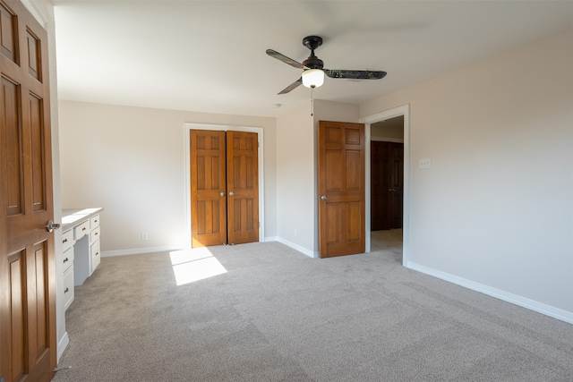 unfurnished bedroom with light carpet, a closet, and ceiling fan