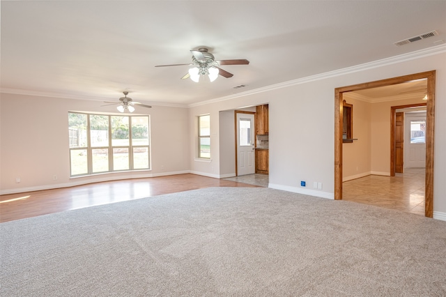 empty room featuring crown molding, light carpet, and ceiling fan