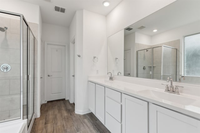 bathroom with wood-type flooring, vanity, and walk in shower