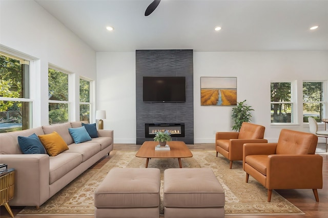 living room featuring ceiling fan, recessed lighting, a large fireplace, baseboards, and light wood-style floors