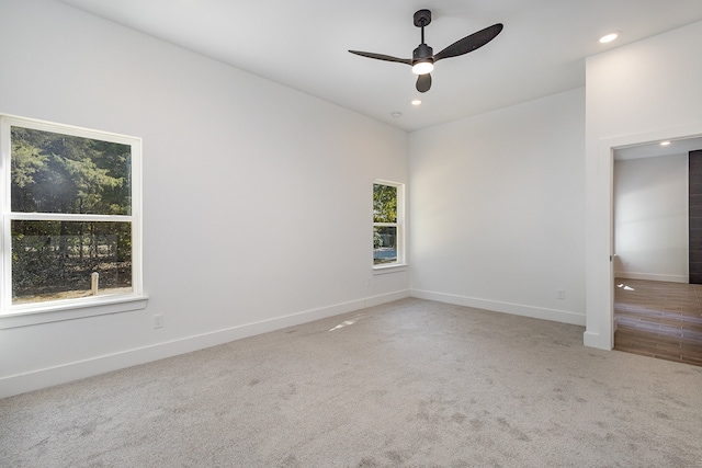 carpeted spare room featuring ceiling fan