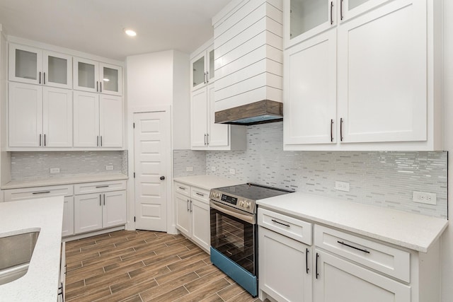 kitchen featuring stainless steel electric range oven, glass insert cabinets, and white cabinetry